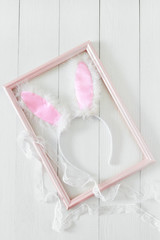 Easter bunny ears in a frame for pictures on a white background. Top view and space for text