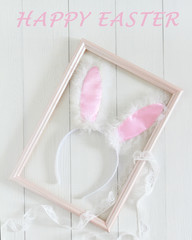 Easter bunny ears in a frame for pictures on a white background. Top view and space for text