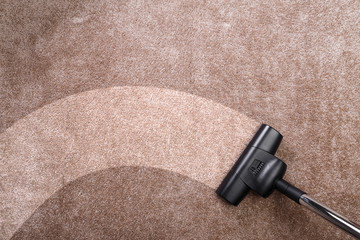 Vacuuming carpet with vacuum cleaner. Housework service. Close up of the head of a sweeper cleaning...