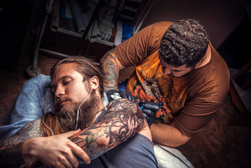 Professional tattooist makes cool tattoo in studio