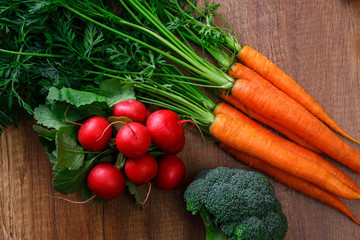 Carrot, red radish and brocoli. Fresh natural vegetables. Organic bio food on wooden table.