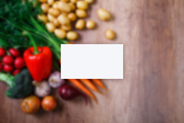 Business card mockup. Potatoes with carrot, garlic and pepper. Red radish, brocoli and raw new potato. Onion. Fresh natural vegetables.