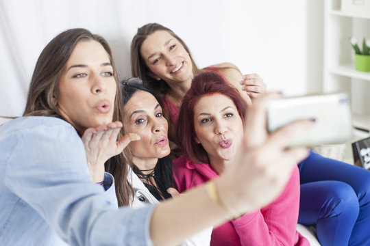 4 beautiful women having fun and taking selfie