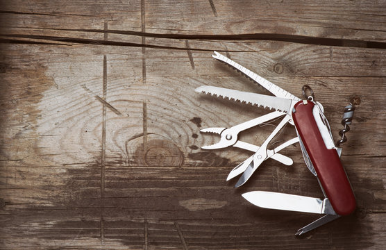 old Swiss knife on a wooden background