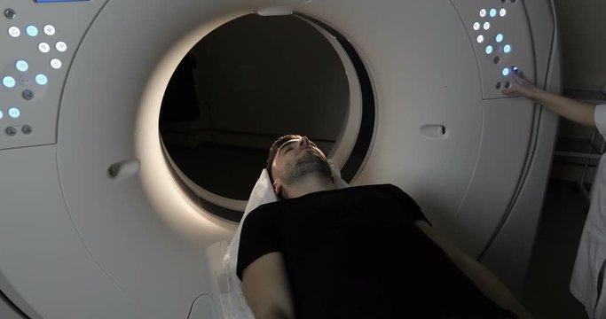 4K Young Man in black T-shirt &nbsp;getting out MRI scanning table.