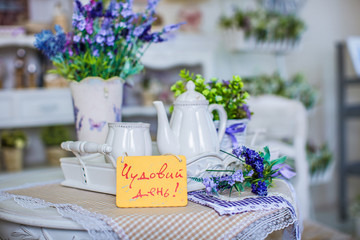 Beautiful composition, with a tea service on the table, on the background of spring flowers.