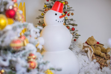 Decorative snowman on background of a Christmas tree