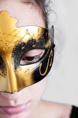 Girl brunette in a theatrical mask looks down