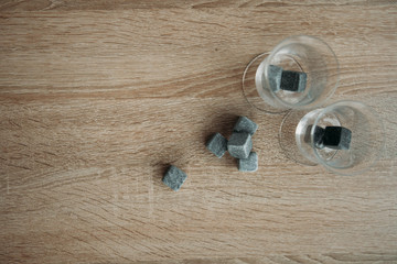 Stones for cooling whiskey and glases tulup on light wooden background