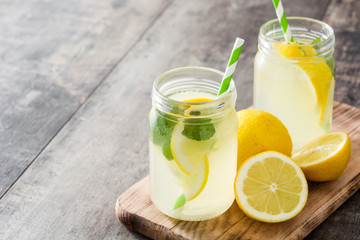 Lemonade drink in a jar glass on wooden background.
