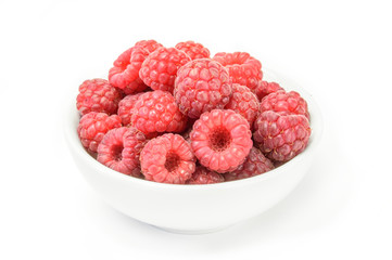 Raspberry fruits at white ceramic cup isolated on background