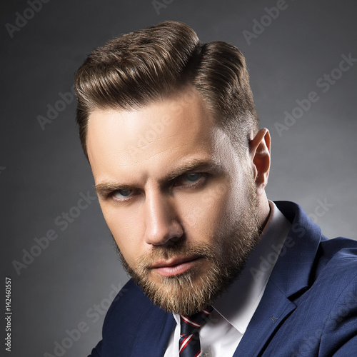 Close Up Face Of Young Man With Beard And Hair Style Wearing Suit