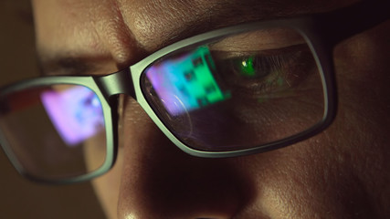 Reflection at eyeglasses of man: looking at a website