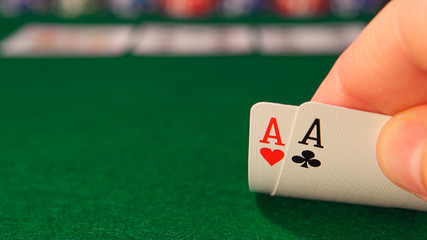 POKER: Player looks his playing cards in the game