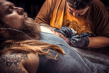 Tattoo master works in tattoo parlor