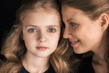 Close-up portrait of beautiful smiling mother and daughter together