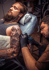 Tattoo master works in tattoo studio