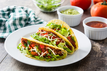 Traditional Mexican tacos with meat and vegetables on wooden background
