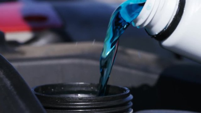 4K Close up of engine coolant being poured into a car