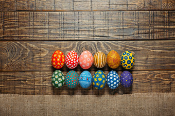 Fototapeta na wymiar Dozen colorful painted Easter eggs on wooden background