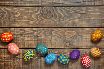 Colorful Easter eggs on wooden background with space