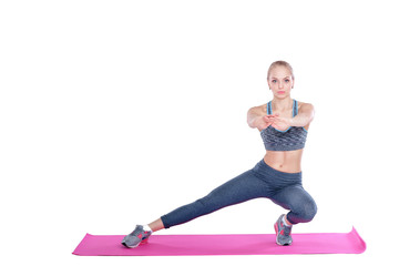 beautiful blonde woman does exercises on  fitness Mat on white background. stretching