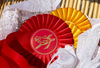 Award rosettes in equestrian sport, red and yellow. Prize ribbons for horse show, champion competition. - obrazy, fototapety, plakaty