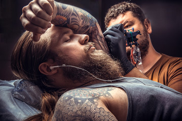 Tattoo master at work in tattoo studio