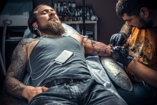 Professional tattoo artist makes tattoo pictures in tattoo studio