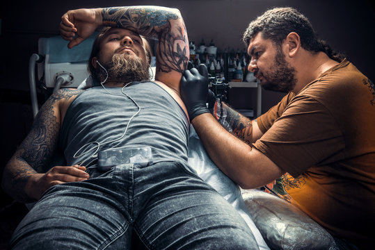 Tattoo specialist makes tattoo in tattoo parlor