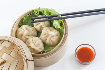 Steamed pork buns in bamboo basket, serve with chopsticks Closed up