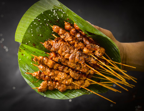 Chicken satay skewers and banana leaf