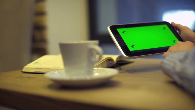 Man using Tablet with Green Screen in cafe. Video can be used in coffee house
