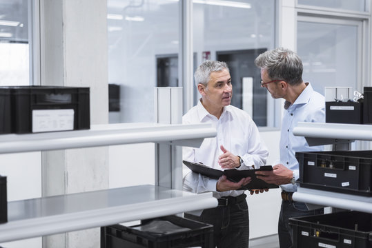 Two managers with files standing in company, discussing