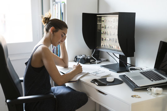 Female photographer editing images at desk