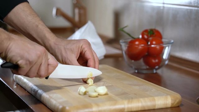 man chopped garlic to prepare bruschetta
