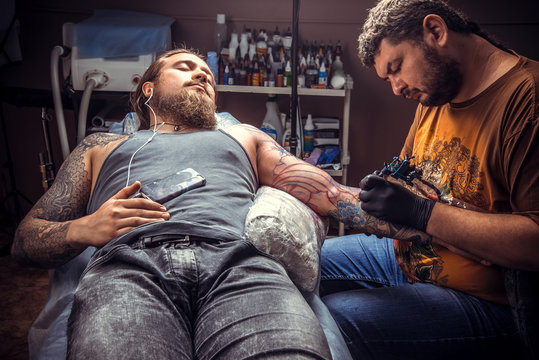 Tattoo master making a tattoo in tattoo parlor