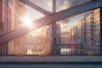 bicycle parked on bridge in Hamburg old warehouse district Speicherstadt during sunset