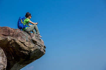 successful woman hiker taking photo with cellphone on mountain top