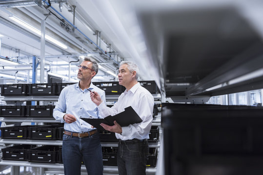 Two managers with files standing in company, discussing