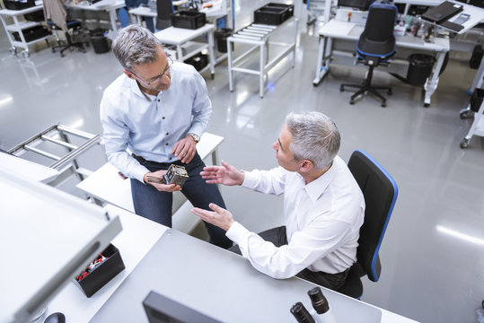 Two managers discussing product in company