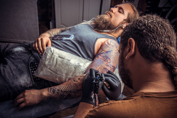 Professional tattoo artist working tattooing in tattoo parlor