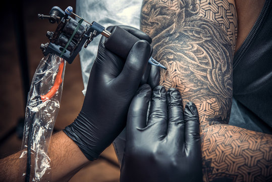 Professional tattooist making a tattoo in studio