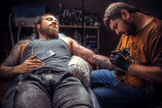 Tattooer at work in tattoo studio