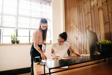 Obraz premium Two business women reading documents on desk