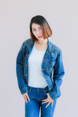 Asian woman casual outfits standing in jeans and blue denim shirt, women brown hair and short hair, smiling and wearing jeans jacket, beauty and fashion Jeans concept, space wall background