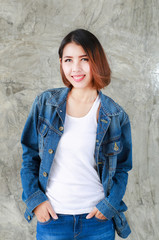 Closeup Asian woman casual outfits standing in jeans and blue denim shirt, women brown hair and short hair, smiling and wearing jeans jacket, beauty and fashion Jeans concept, space wall background