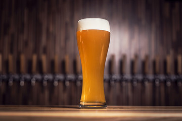 Cleer beer in mug stands on the bar against the background of the taps