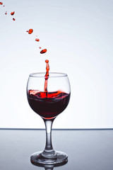 moving red wine glass over a white background