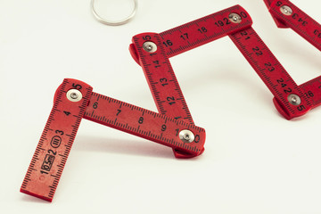 Red foldable ruler with numbers on a white background